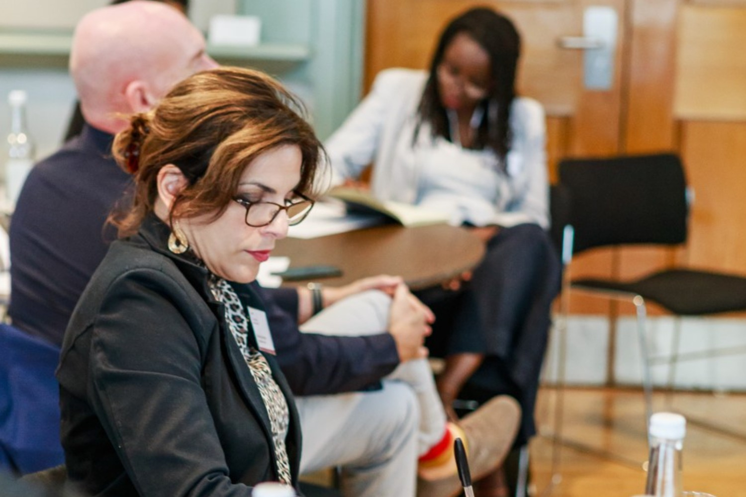 Image of a female member sat a table at one of our in-person events, concentrating as she reads