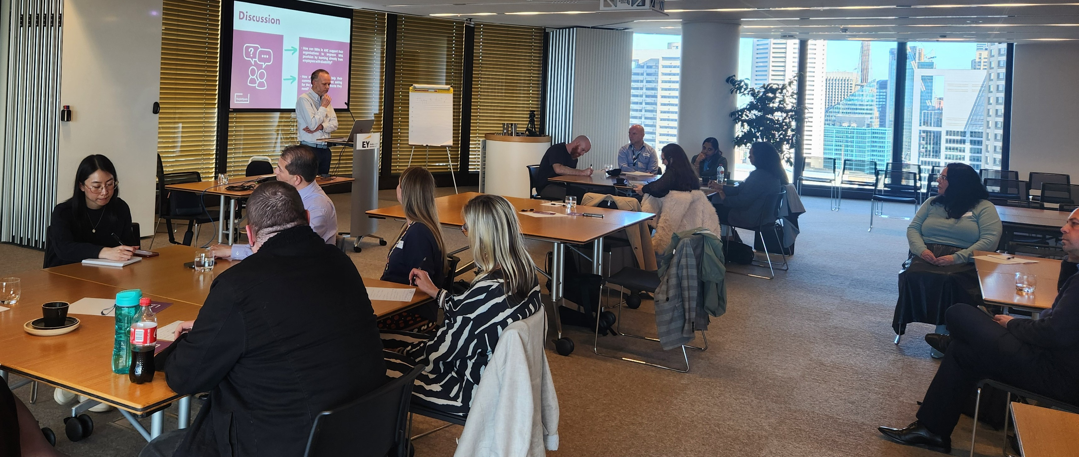 Wide shot of attendees sat at tables during the ANZ session at EY